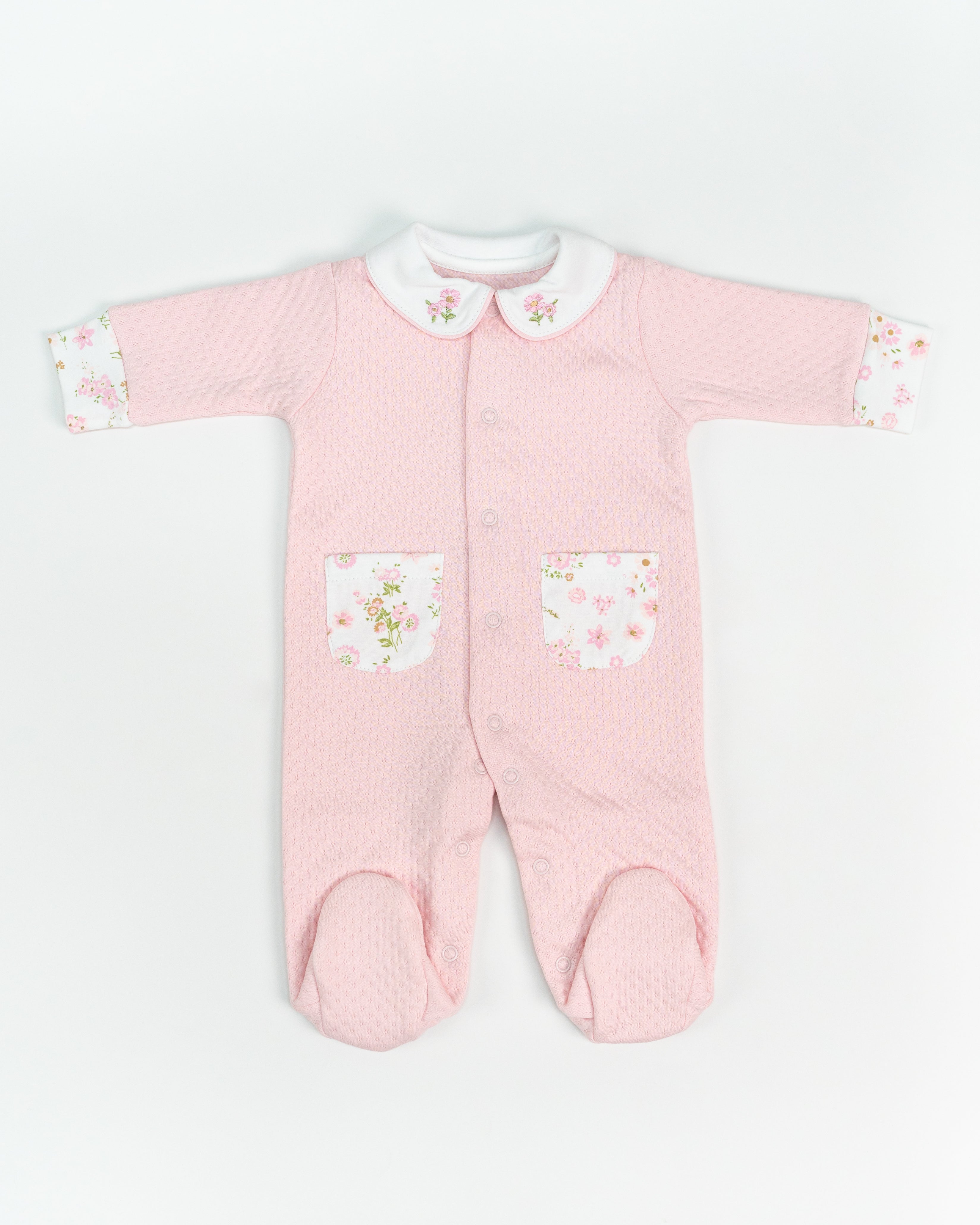 Pink baby onesie with floral details on a white background